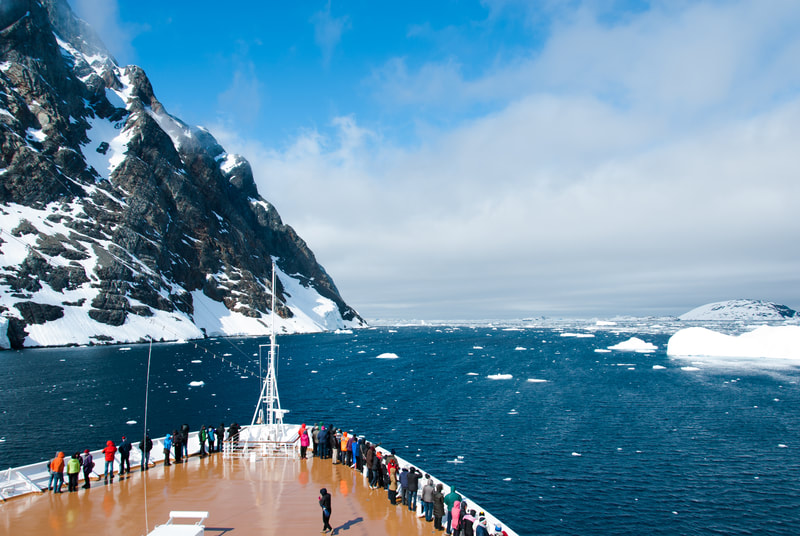 Cruise through Antarctic waters with mountains and icebergs